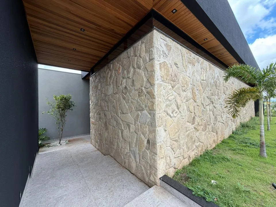 Detalhe da marquise com forro de madeira e muro de pedra
