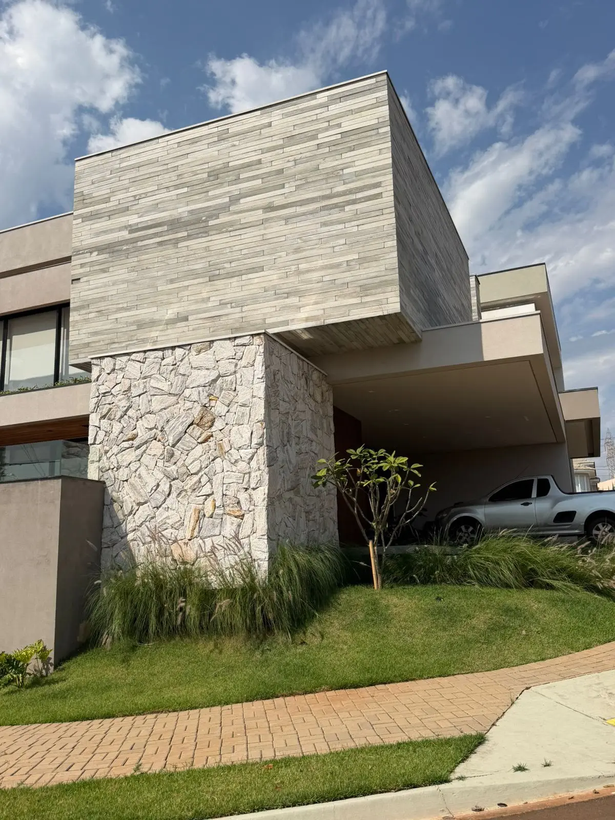 Sobrado projetado pela Picprédio, com volume em balanço apoiado sobre pilar revestido em pedra